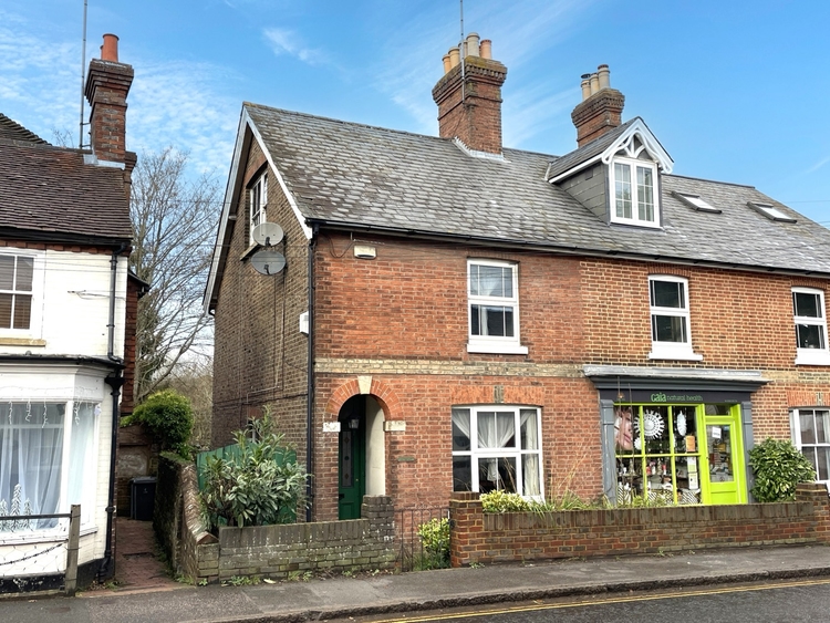 A brick end-terrace house on a UK residential street, of the kind Augusta buys through probate