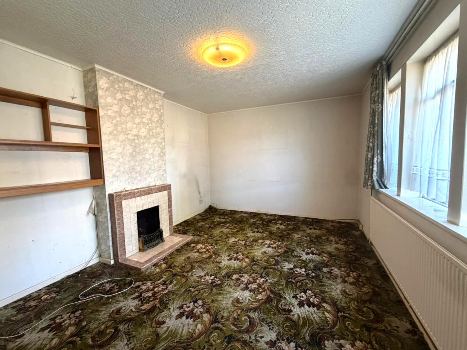 The front room of an empty inherited house, cleared but not yet modernised